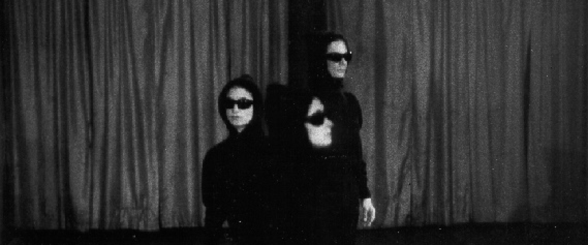 Jenkins, Rudner, Tharp in Twelve Foot Change wearing sunglasses and parkas and standing in a line
