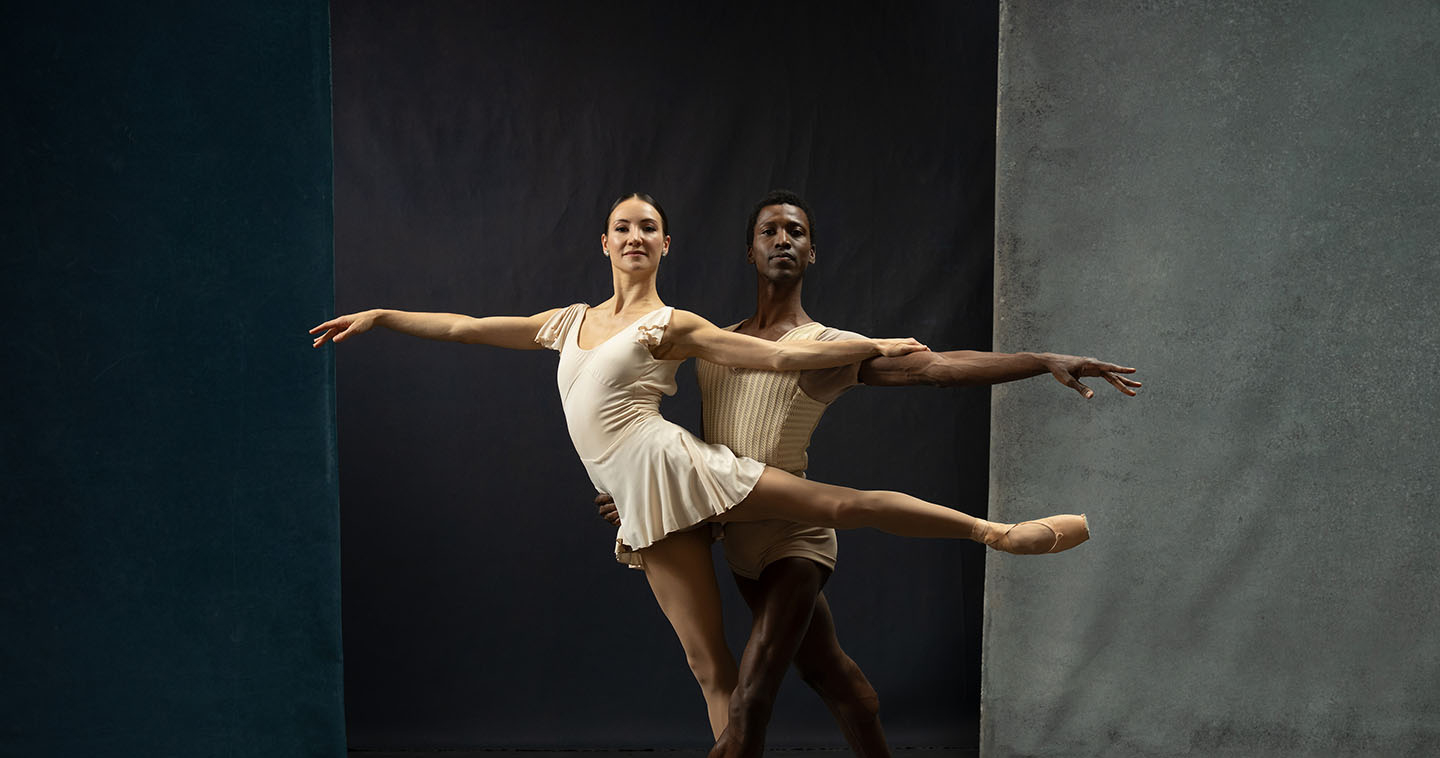 A female dancer in arabesque held by a male dancer.